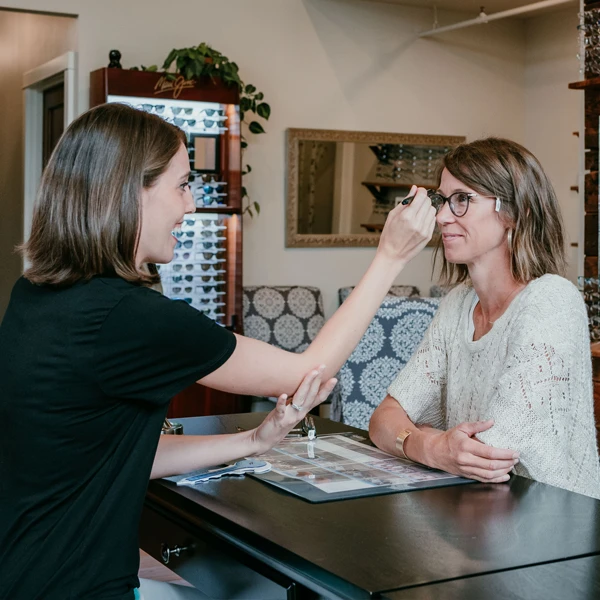 A patient sits in the lobby of Owen Eye Care, being measured for their new frames to ensure perfect fit
